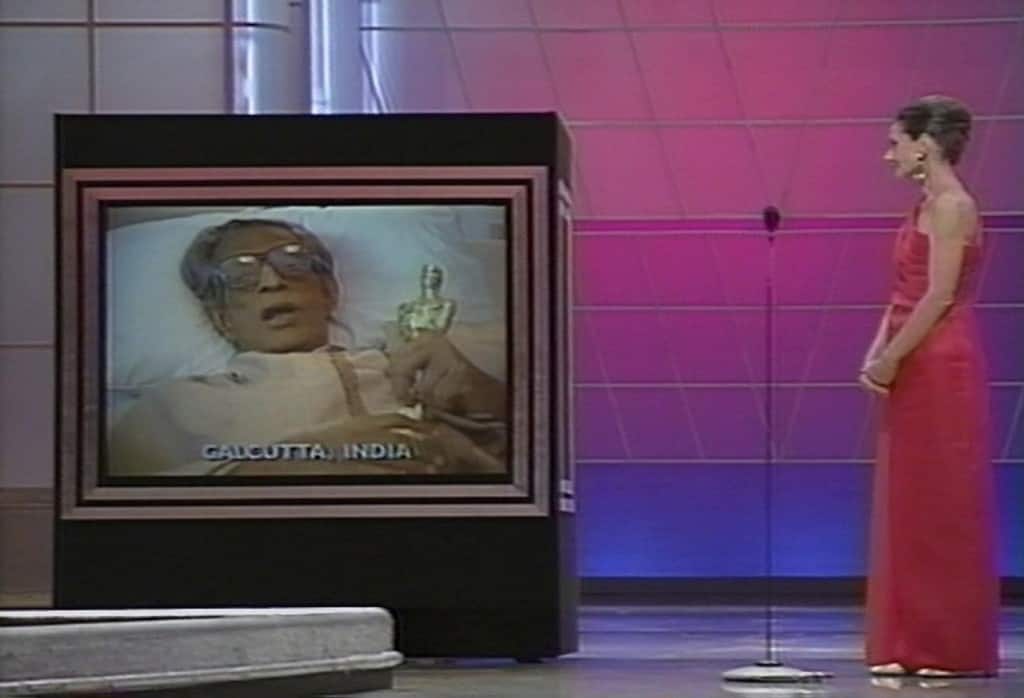 Audrey Hepburn watching the monitor as Satyajit Ray gives his acceptance speech