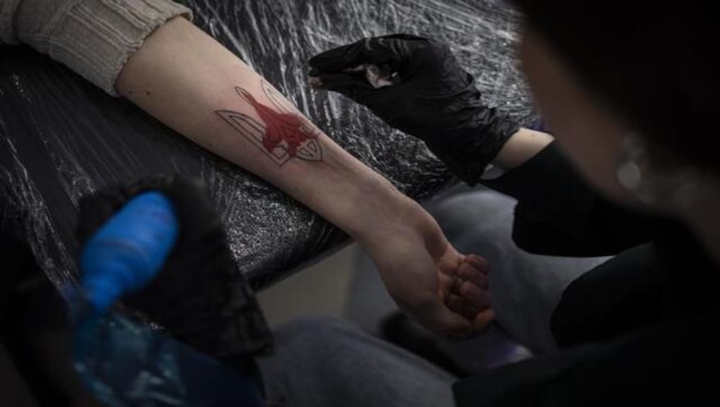Ukrainian Olena Barlevych gets a patriotic-themed tattoo at her workshop in Lviv, Western Ukraine, 19 March, 2022. AP/File