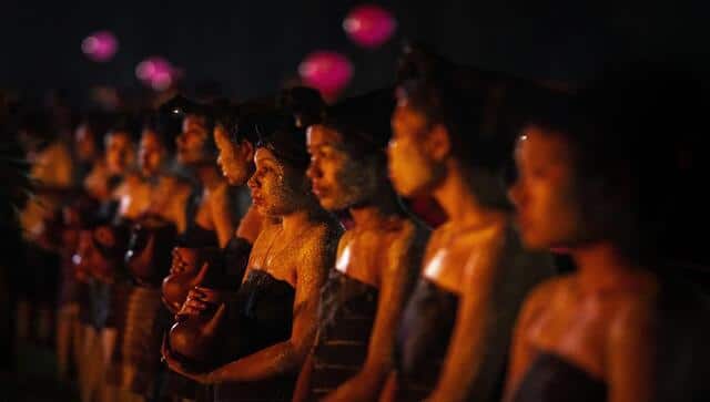 Rabha tribal girls in traditional attire hold earthen pots filled with traditional rice beer to serve Rabha Hindu priests after they walk barefoot over burning charcoal as part of rituals. AP