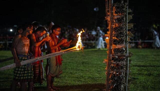 Indian Rabha tribal Hindu priests perform rituals before burning wood during Baikho festival at Gamerimura village