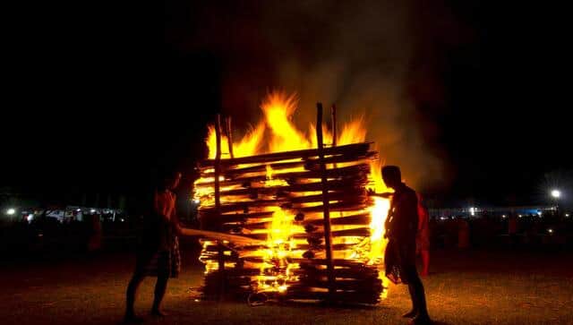 Indian Rabha tribal Hindu priests burn wood during Baikho festival at Gamerimura village along the Assam Meghalaya border