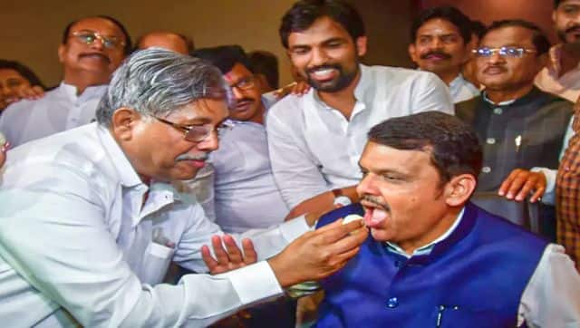 Former Maharashtra chief minister and BJP leader Devendra Fadnavis being fed sweets by Maharashtra BJP president Chandrakant Patil during a party meeting, at Taj President Hotel in Mumbai. PTI 