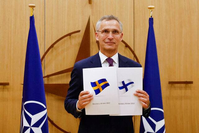 NATO Secretary-General Jens Stoltenberg displays documents as Sweden and Finland applied for membership in Brussels, Belgium, 18 May, 2022. AP File
