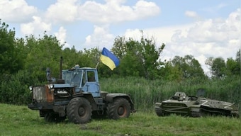 Tanks-in-tug: Pics of Ukrainian farmers towing busted Russian tanks are defining symbols of resistance