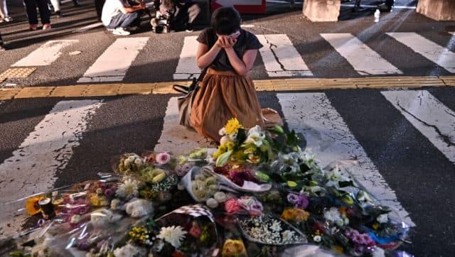 A woman breaks down outside Yamato-Saidaiji Station in Nara where former Japanese prime minister Shinzo Abe was assassinated. AP