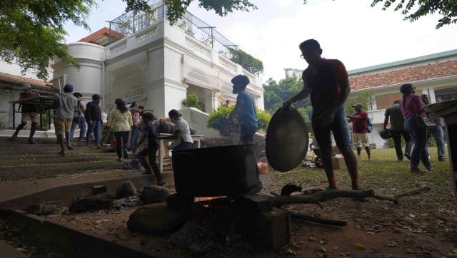 Protesters cook their meals using a firewood hearth at the premises of prime minister's official residence a day after vandalising it in Colombo, Sri Lanka. AP