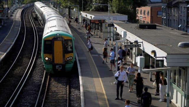 Commuters wait for their train on a platform at West Norwood station in south London amid disruption warnings over extreme heat. AFP