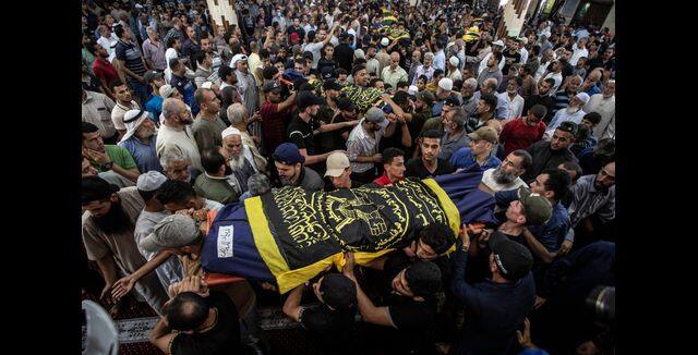 Mourners carry the bodies of Khaled Mansour a senior commander in the Palestinian militant group Islamic Jihad and other Palestinians, who were killed in Israeli airstrikes. AP