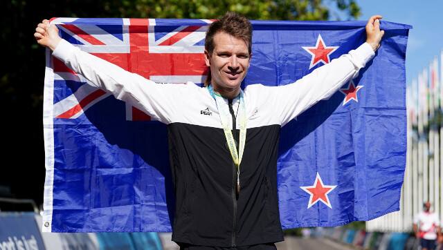 New Zealand's Aaron Gate celebrates with his gold medal after winning the Men's Road Race in Warwick, England on day ten of the 2022 Commonwealth Games, Sunday Aug. 7, 2022. (David Davies/PA via AP)