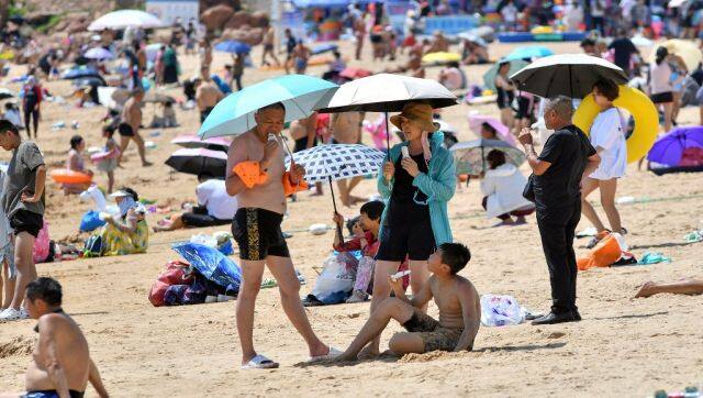 People relax on a beach amid hot weather in Qingdao, in China's eastern Shandong province. AFP