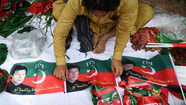 A vendor sells flags of Pakistan Tehreek-e-Insaf (PTI) party portraying Pakistan's former prime minister Imran Khan, outside the Khan's residence in Islamabad. AFP