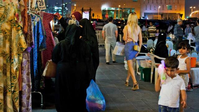 FILE - A foreign woman wearing a short dress walks at Souq Waqif in Doha, Qatar, Monday, June 2, 2014. Qatar has sought to portray itself as welcoming foreigners to this hereditarily ruled emirate, where traditional Muslim values remain strong.(AP Photo/Razan Alzayani, File)