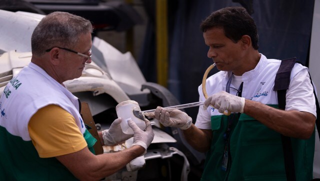To fight dengue epidemic, health agents in Brazil scour junkyards and roofs for mosquitos