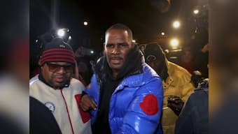 R Kelly turns himself in to Chicago police after being charged with sexual abusing underage girls
