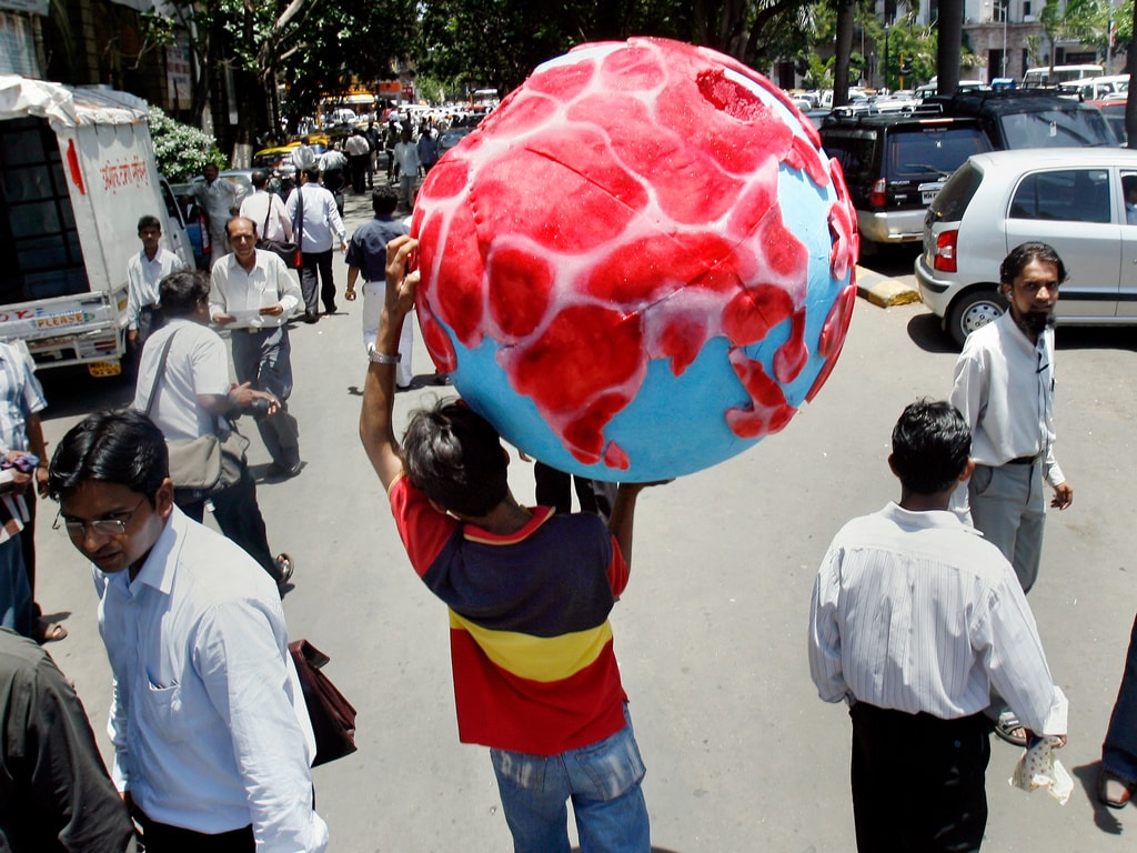 An activist carries a globe with the land masses represented by 