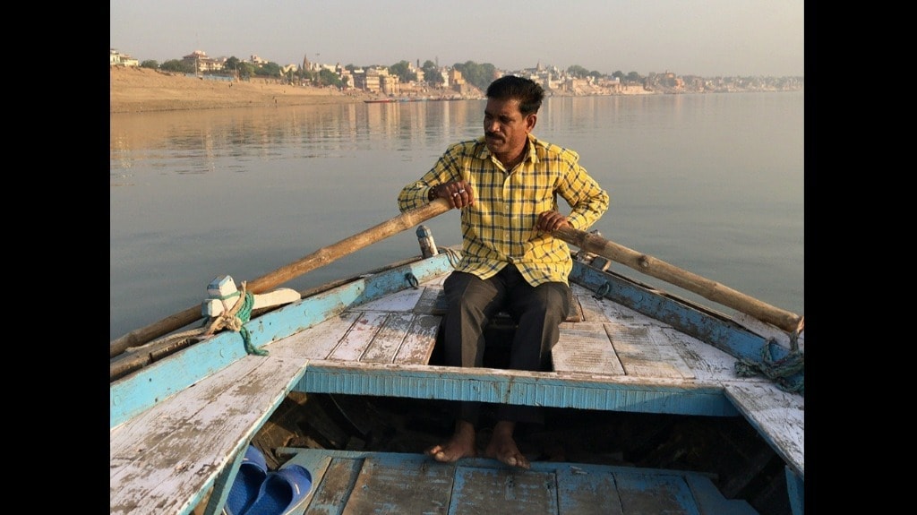 Varanasi boatman Pradeep Manjhi rows in a polluted Ganga. Photo by Joydeep Gupta
