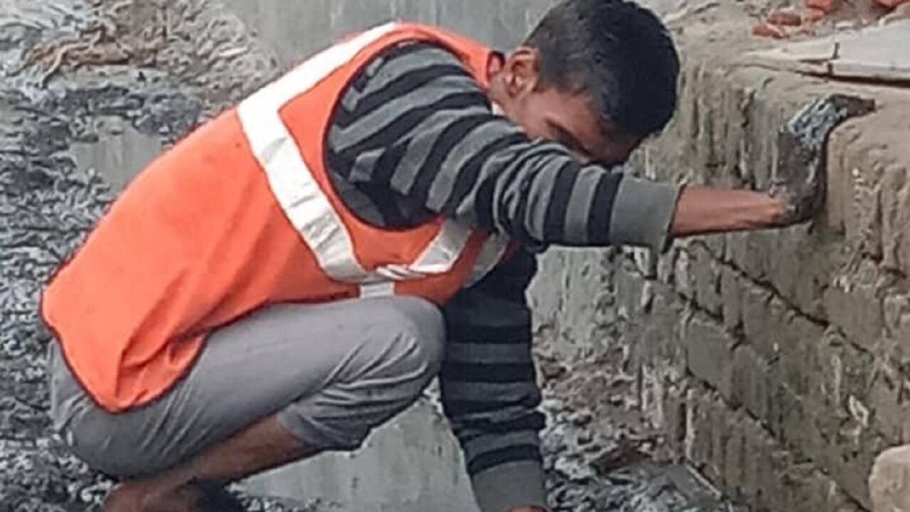 Pictures of sanitation workers in Noida cleaning drains without
