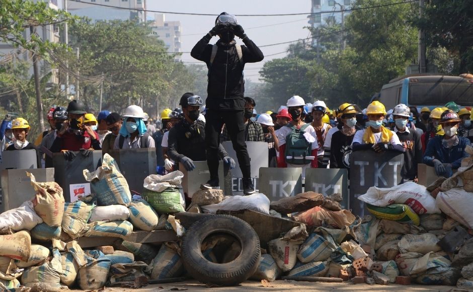 In this 7 March, 2021, file photo, protesters take positions behind a barricade as police gather in Yangon, Myanmar. (AP Photo, File)