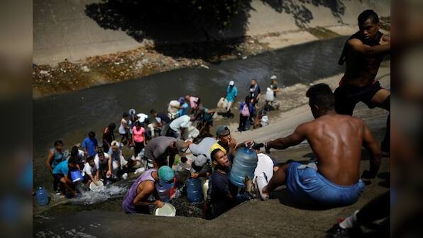 Desperate Venezuelans swarm sewage drains in search of water