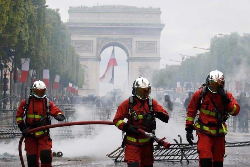 French police fire tear gas as protests follow Bastille Day parade