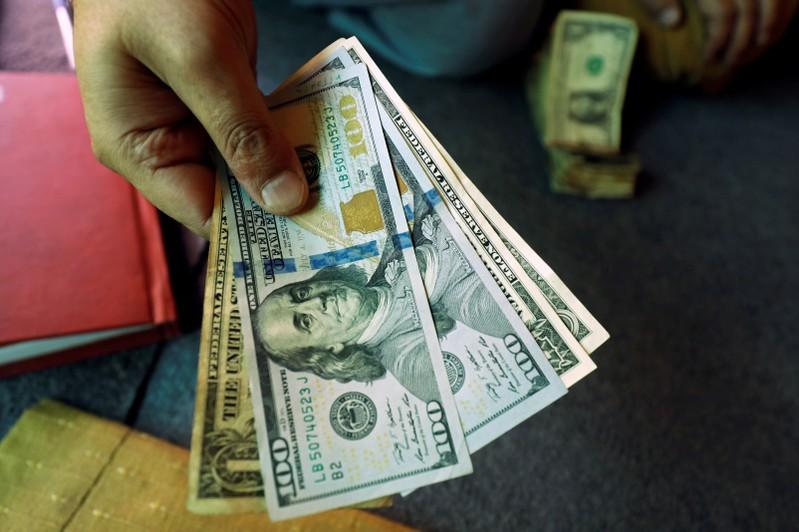 Dollar holds gains as investors cling to trade hopes