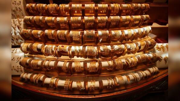 Gold firms as dollar eases, markets brace for Fed